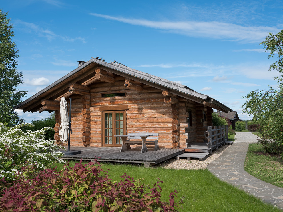 This is an example of a rustic detached house in Moscow with wood cladding and a pitched roof.