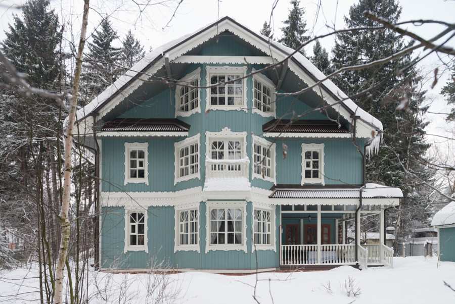 Example of a mid-sized cottage blue two-story wood exterior home design in Moscow with a gambrel roof