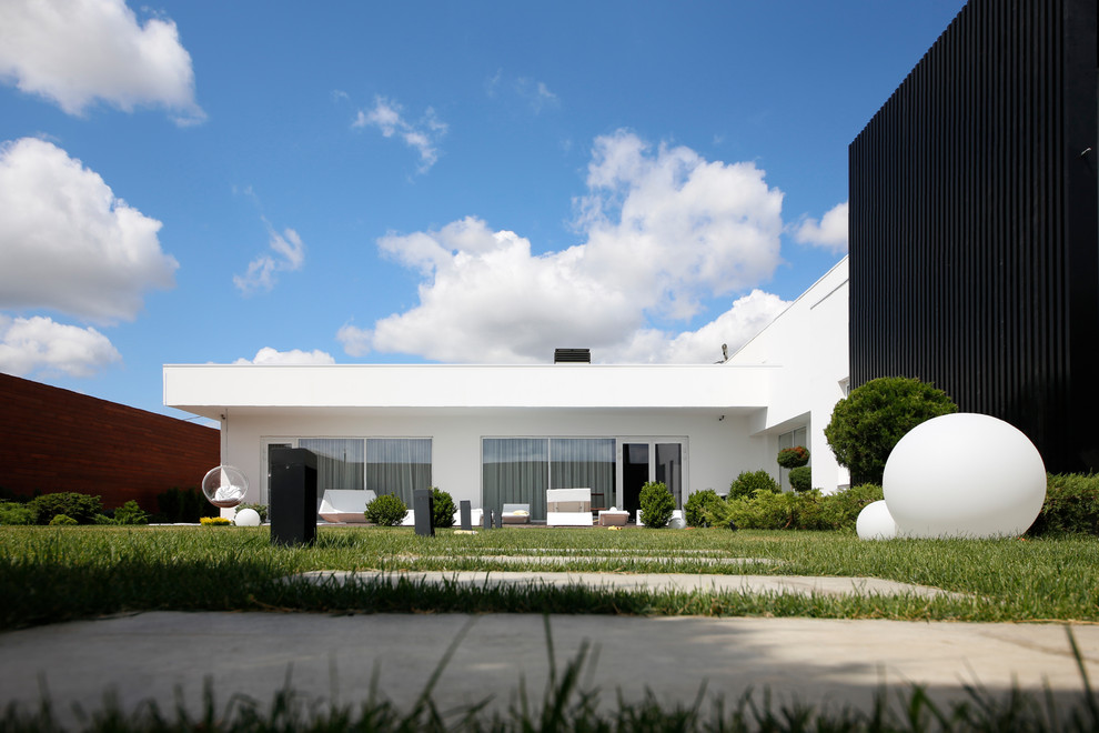 Kleines, Einstöckiges Modernes Einfamilienhaus mit Putzfassade, weißer Fassadenfarbe, Flachdach und Misch-Dachdeckung in Sonstige