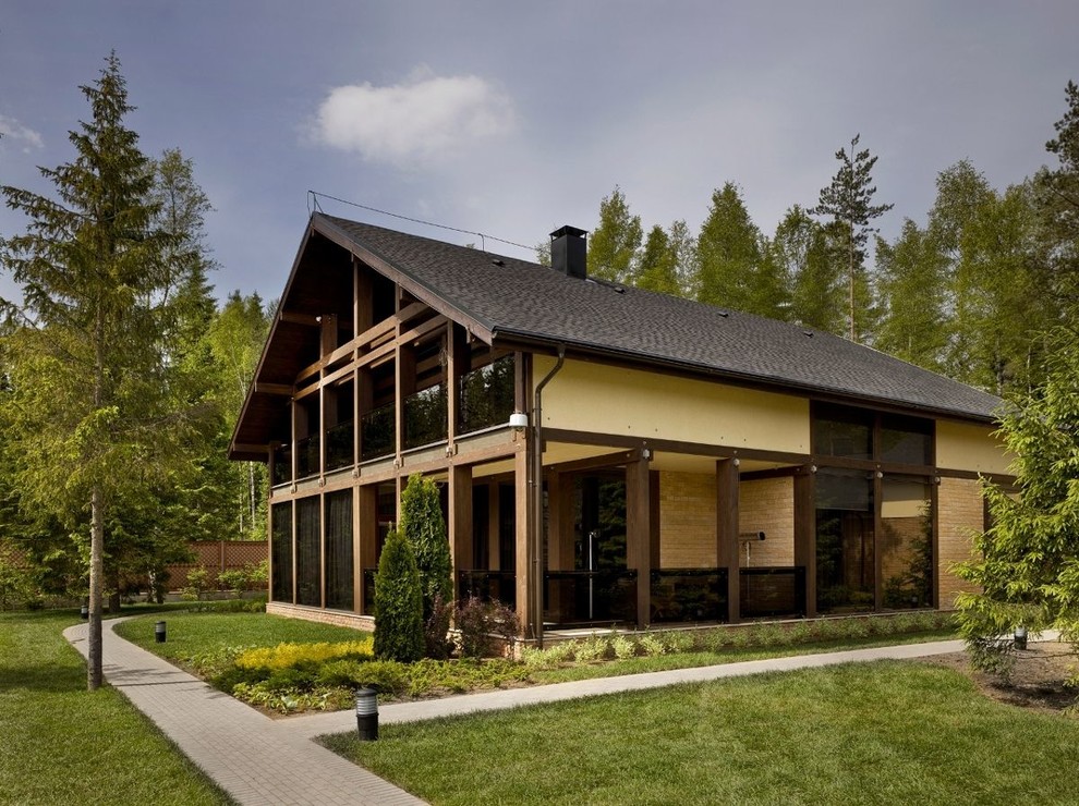 Пример оригинального дизайна: коричневый частный загородный дом в стиле рустика с двускатной крышей