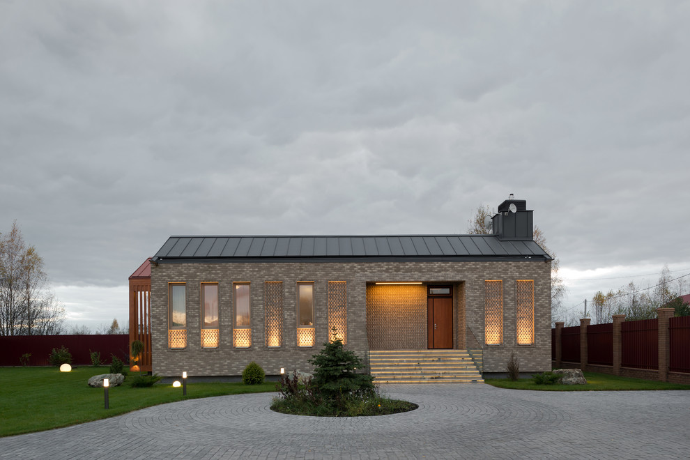 Réalisation d'une façade de maison multicolore design en brique de taille moyenne et de plain-pied avec un toit à deux pans.