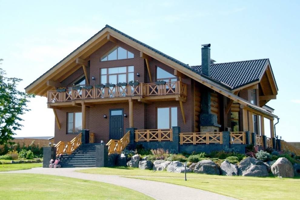 Foto della facciata di una casa marrone country con rivestimento in mattoni e tetto a capanna