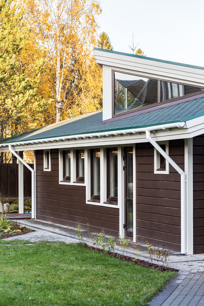 Diseño de fachada de casa marrón contemporánea de tamaño medio de una planta con revestimiento de madera, tejado a dos aguas y tejado de teja de madera