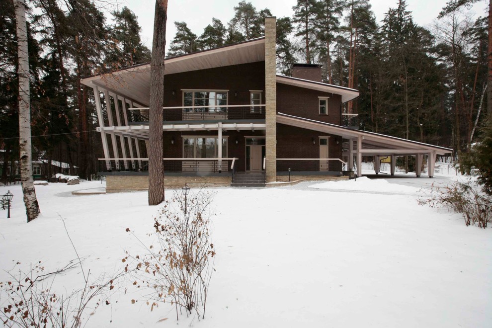 Пример оригинального дизайна: двухэтажный, коричневый частный загородный дом среднего размера в современном стиле с комбинированной облицовкой, односкатной крышей и металлической крышей