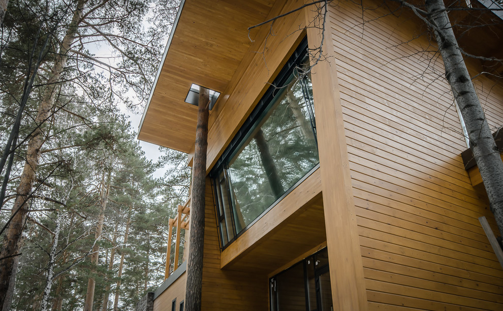 Стильный дизайн: двухэтажный, деревянный, коричневый дом среднего размера в современном стиле с плоской крышей - последний тренд