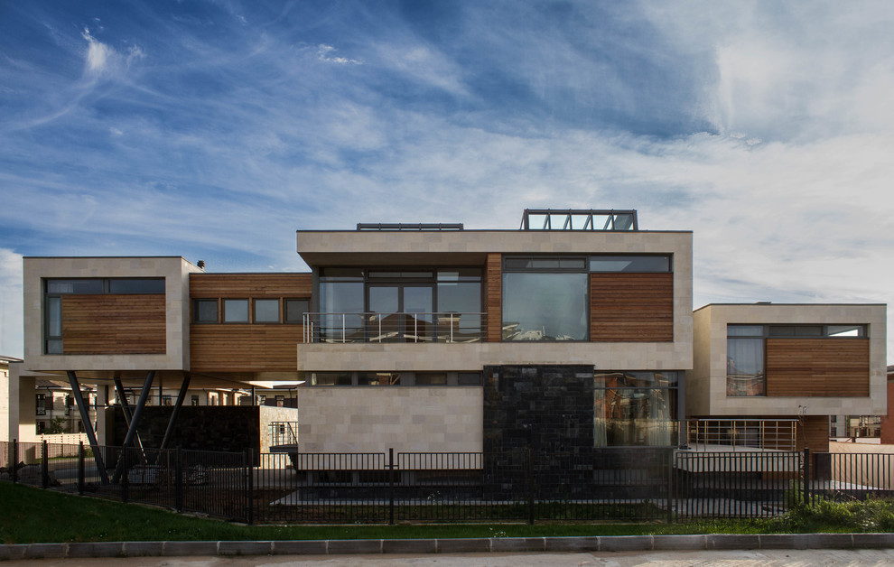 Стильный дизайн: большой, двухэтажный частный загородный дом в современном стиле с комбинированной облицовкой и плоской крышей - последний тренд