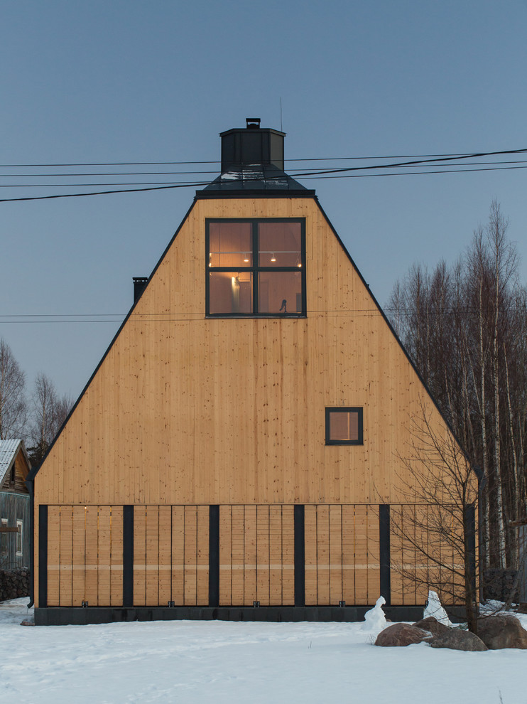 Ejemplo de fachada de casa amarilla rústica de tamaño medio de tres plantas con revestimiento de madera, tejado a doble faldón y tejado de metal