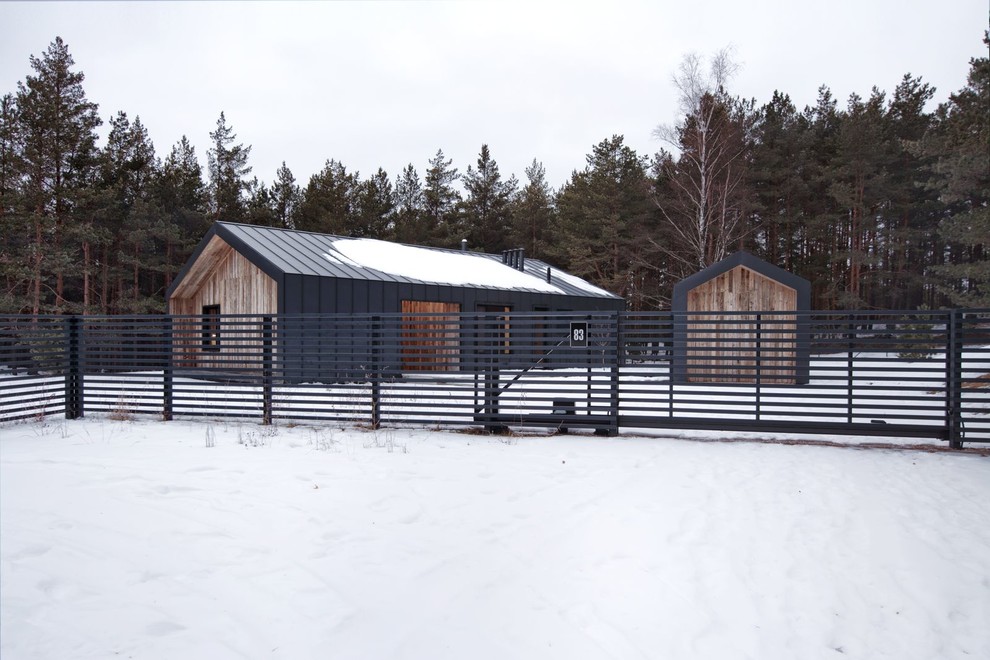 Idee per la villa piccola nera a un piano con rivestimento in legno, tetto a capanna e copertura in metallo o lamiera