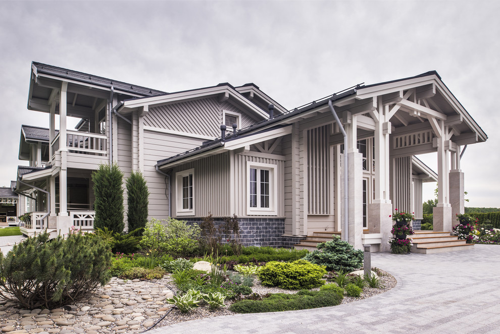 Diseño de fachada de casa gris clásica renovada grande de dos plantas con revestimiento de madera, tejado a dos aguas y tejado de teja de madera