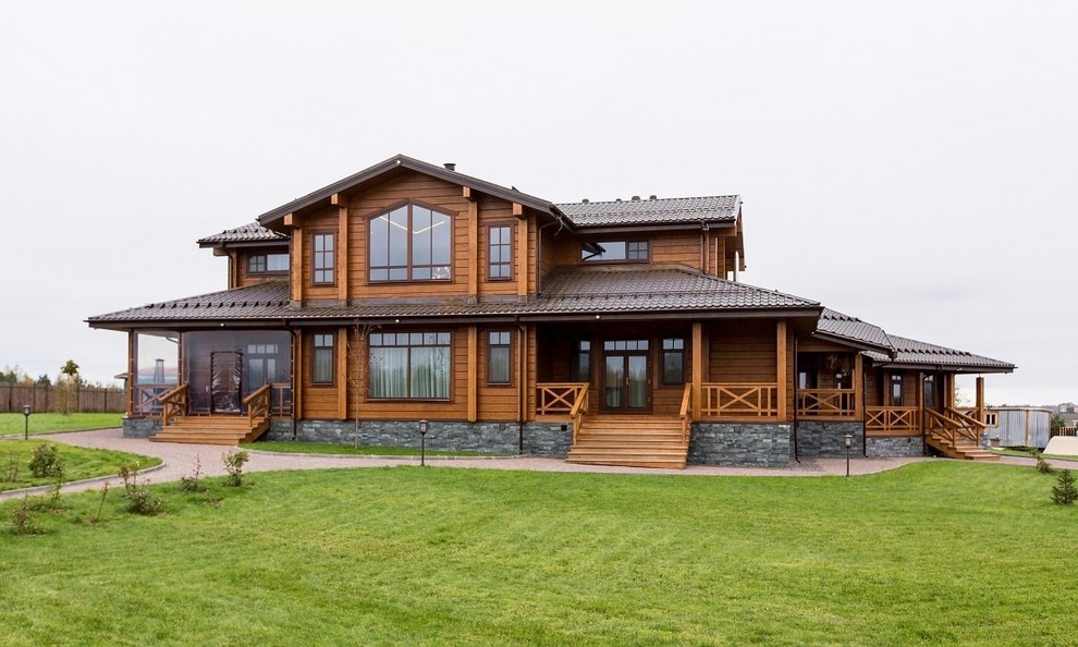 Идея дизайна: двухэтажный, деревянный, коричневый частный загородный дом в стиле кантри с двускатной крышей