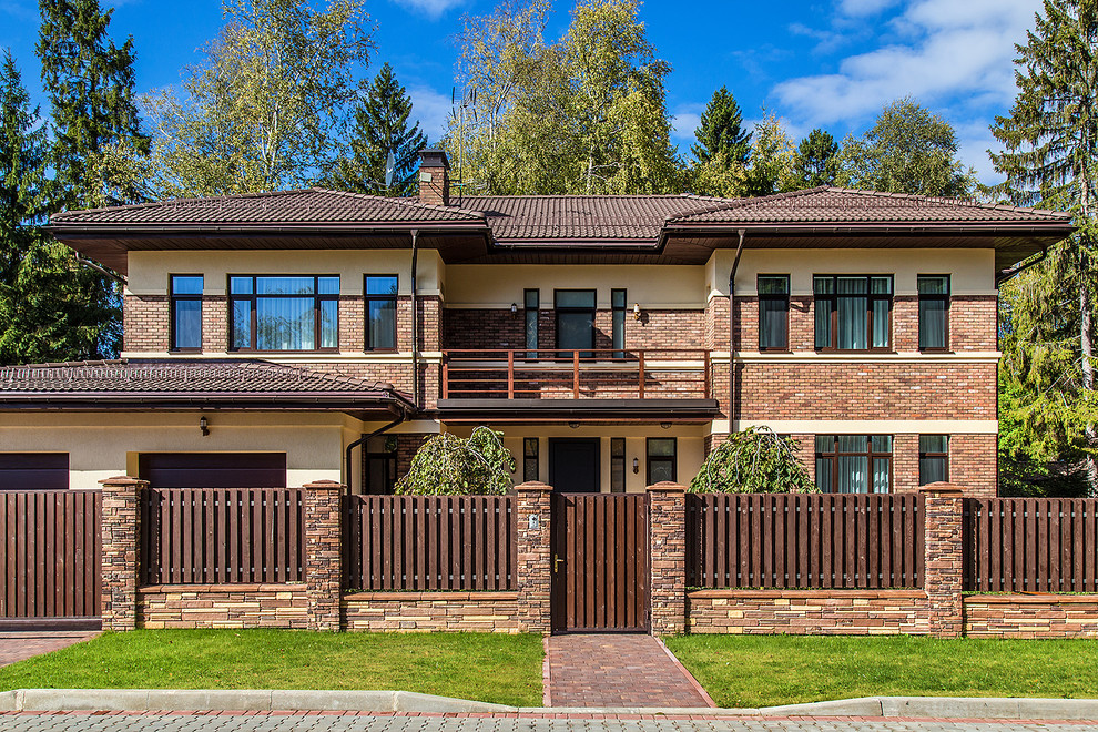 This is an example of a brown contemporary two floor detached house in Moscow with mixed cladding, a hip roof and a tiled roof.