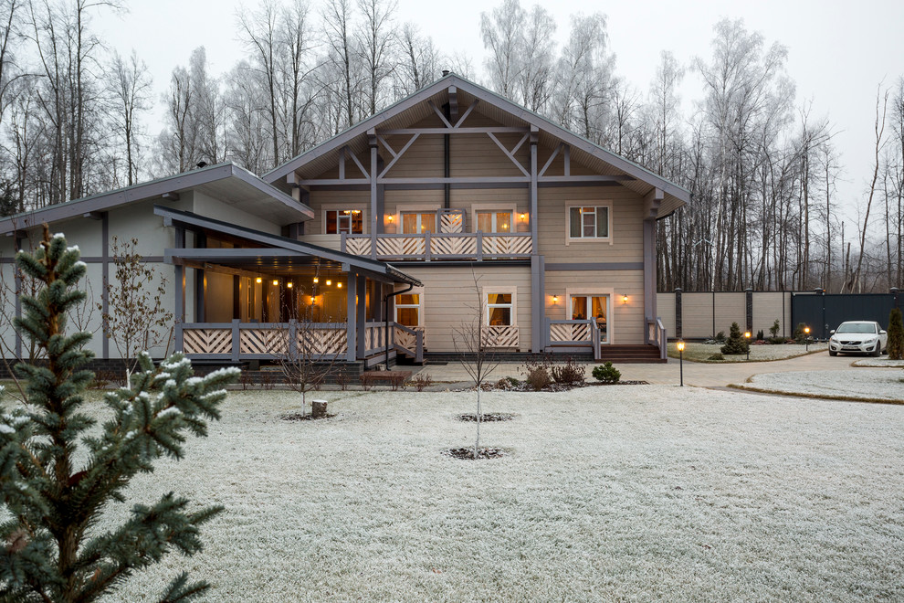 Immagine della facciata di una casa beige country a due piani con rivestimento in legno e tetto a capanna