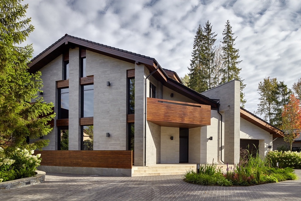 На фото: серый, двухэтажный дом в современном стиле с двускатной крышей