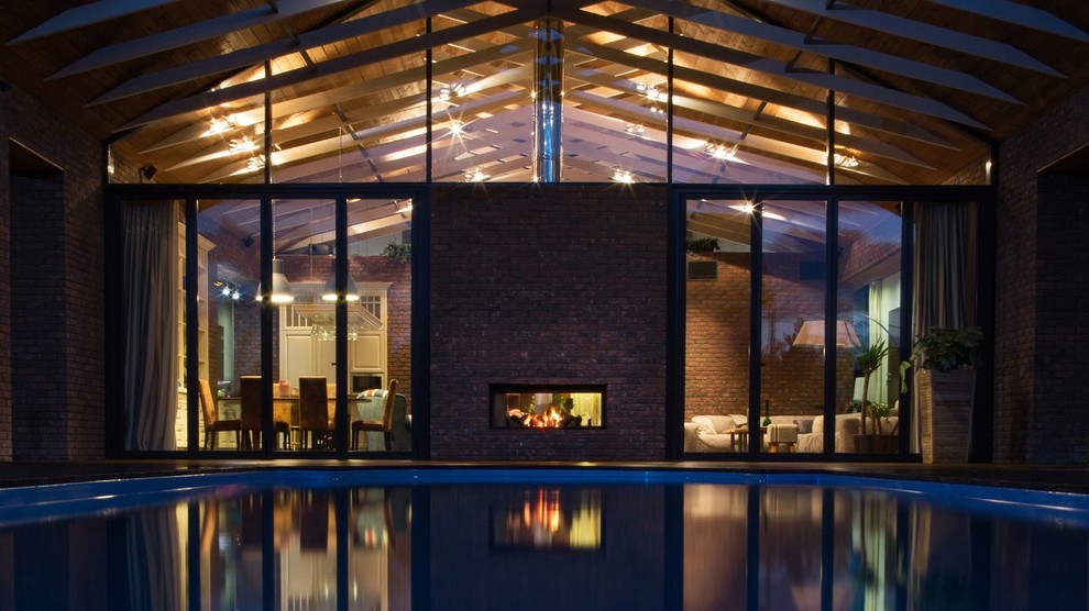 Immagine della villa grande marrone contemporanea a un piano con rivestimento in mattoni, tetto a capanna e copertura in tegole