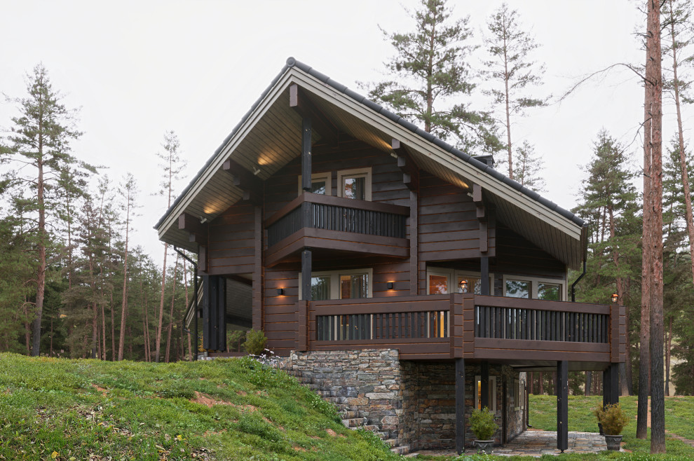 Пример оригинального дизайна: двухэтажный, деревянный, коричневый частный загородный дом в стиле кантри с двускатной крышей