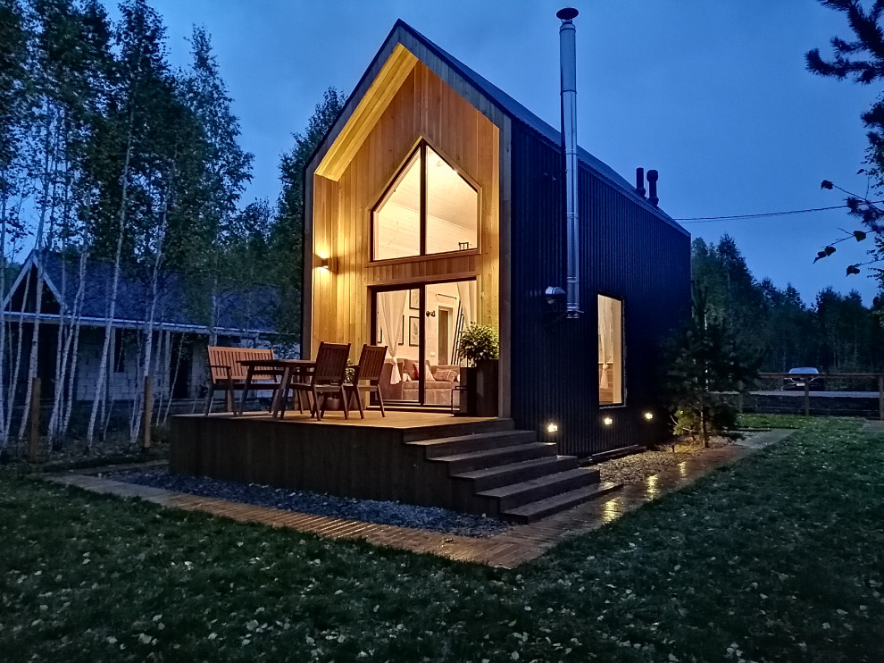 Стильный дизайн: маленький, двухэтажный, деревянный, коричневый частный загородный дом в скандинавском стиле с двускатной крышей и металлической крышей для на участке и в саду - последний тренд