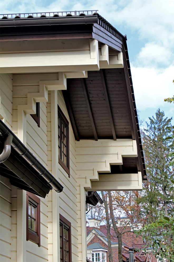 Immagine della facciata di una casa a due piani di medie dimensioni con rivestimento in legno e tetto a capanna