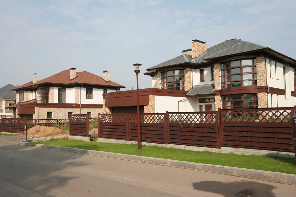Photo of a large and multi-coloured traditional two floor brick detached house in Moscow with a hip roof and a shingle roof.