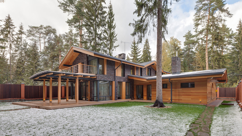 Cette photo montre une façade de maison marron scandinave en bois à un étage avec un toit à deux pans.