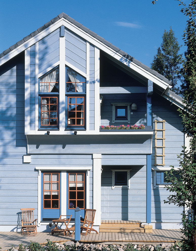 Пример оригинального дизайна: двухэтажный, деревянный, синий частный загородный дом в классическом стиле с двускатной крышей