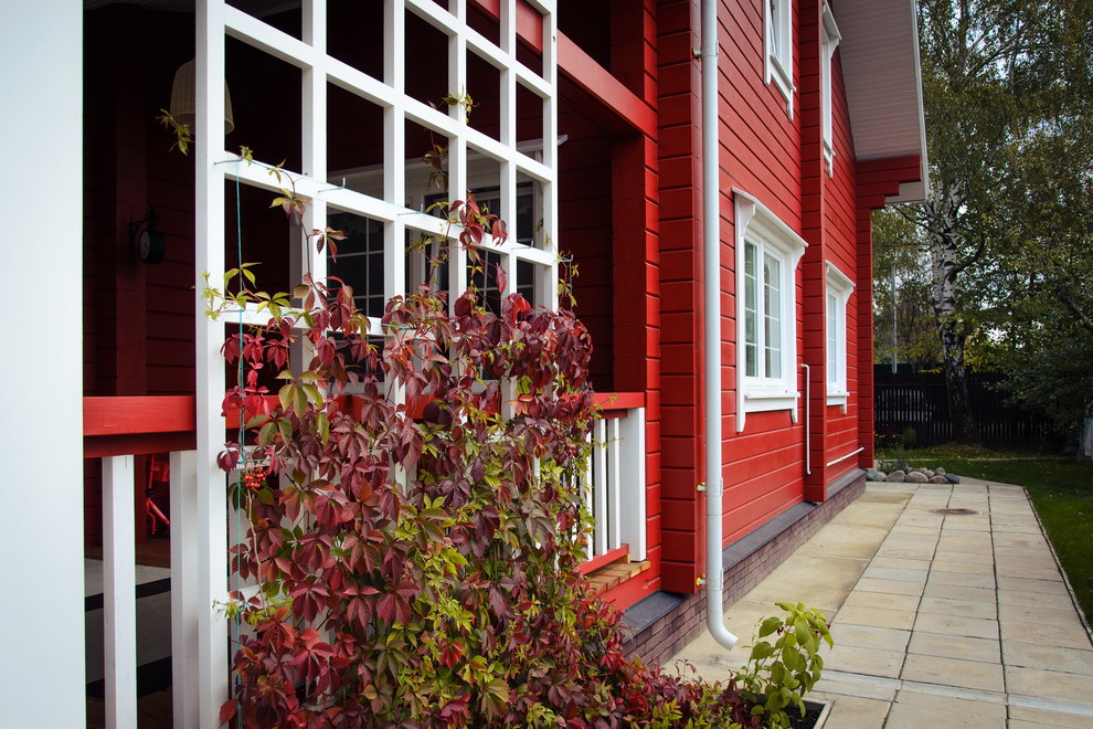 Идея дизайна: двухэтажный, деревянный, красный частный загородный дом в стиле кантри