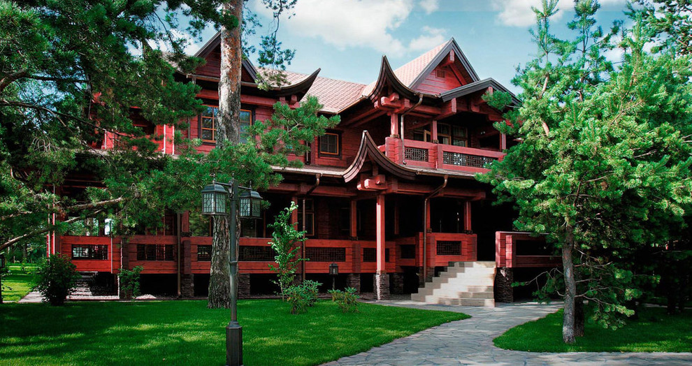 Réalisation d'une façade de maison rouge asiatique en bois à un étage.