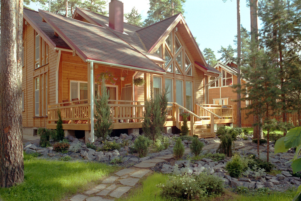 Immagine della facciata di una casa beige scandinava a due piani con rivestimento in legno e tetto a capanna