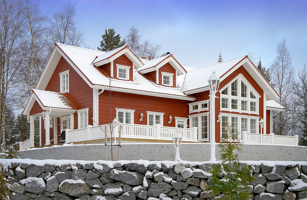 На фото: двухэтажный, деревянный, красный частный загородный дом среднего размера в классическом стиле с двускатной крышей и крышей из гибкой черепицы с
