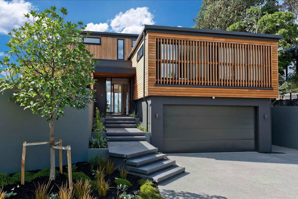Idée de décoration pour une façade de maison grise design en bois à un étage avec un toit plat.