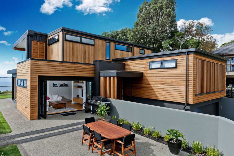Стильный дизайн: двухэтажный, деревянный, коричневый частный загородный дом в современном стиле с плоской крышей - последний тренд