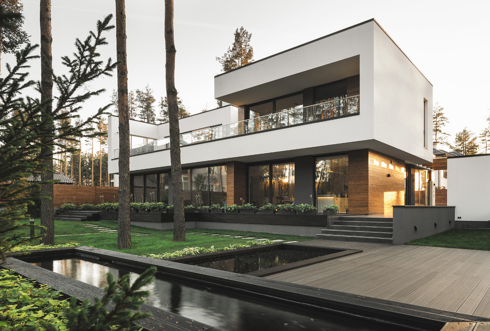 Стильный дизайн: большой, двухэтажный, разноцветный частный загородный дом в современном стиле с комбинированной облицовкой и плоской крышей - последний тренд
