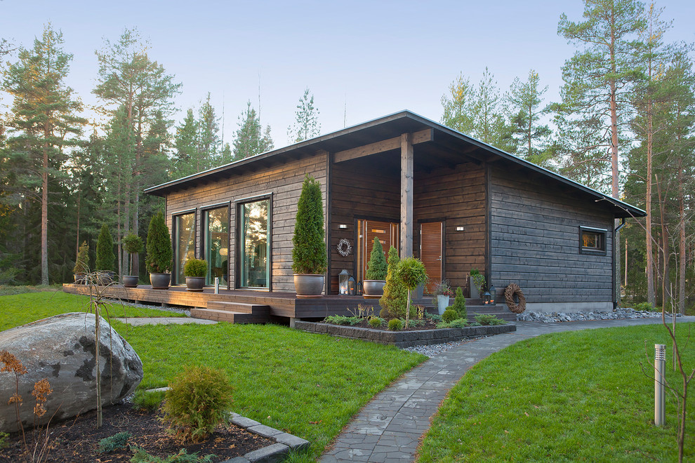 Brown and medium sized rustic bungalow detached house in Moscow with wood cladding and a lean-to roof.