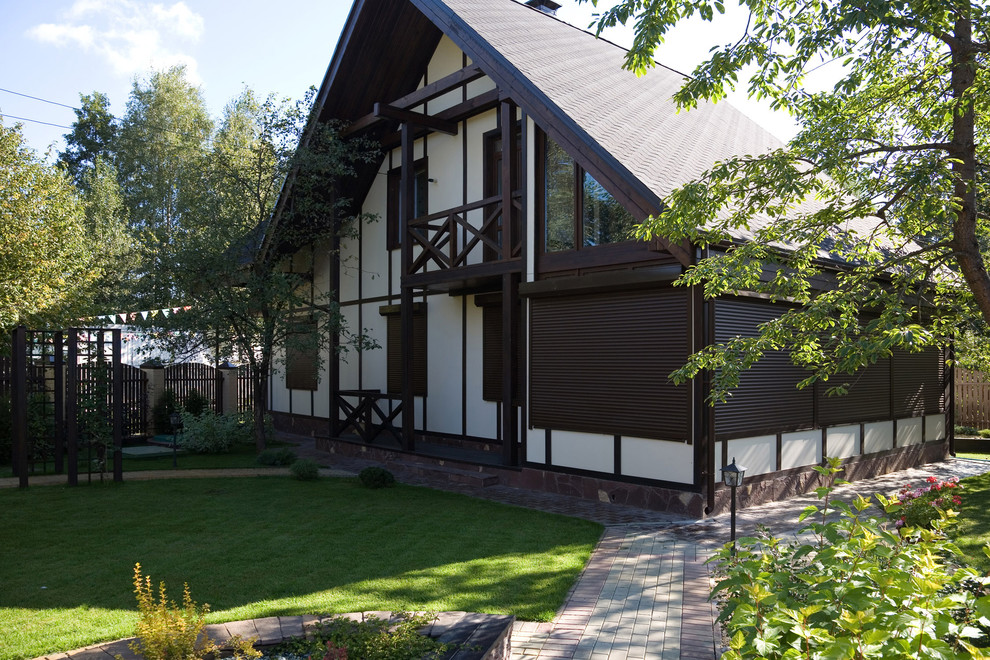 Exemple d'une grande façade de maison marron nature en bois à un étage avec un toit à deux pans.