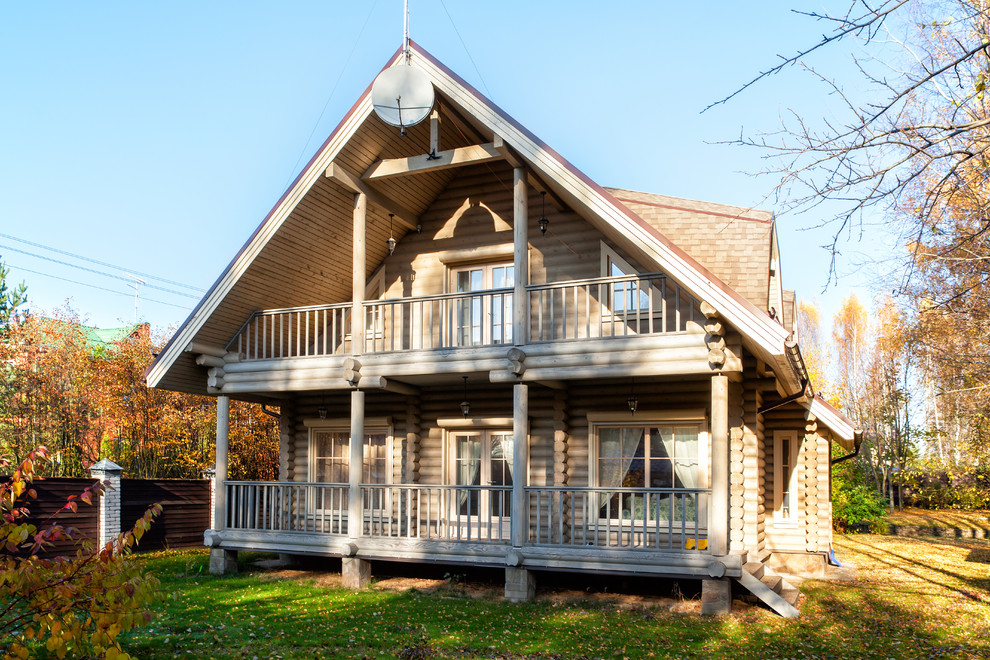 Esempio della villa beige rustica a due piani di medie dimensioni con rivestimento in legno, tetto a capanna e copertura a scandole