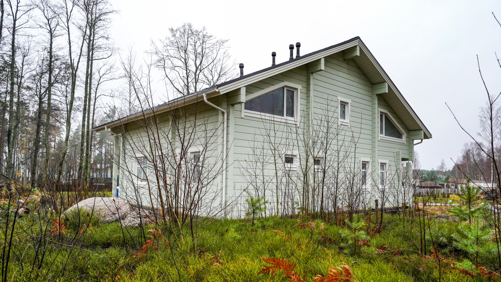 Idee per la villa verde scandinava a due piani di medie dimensioni con rivestimento in legno, tetto a capanna e copertura a scandole