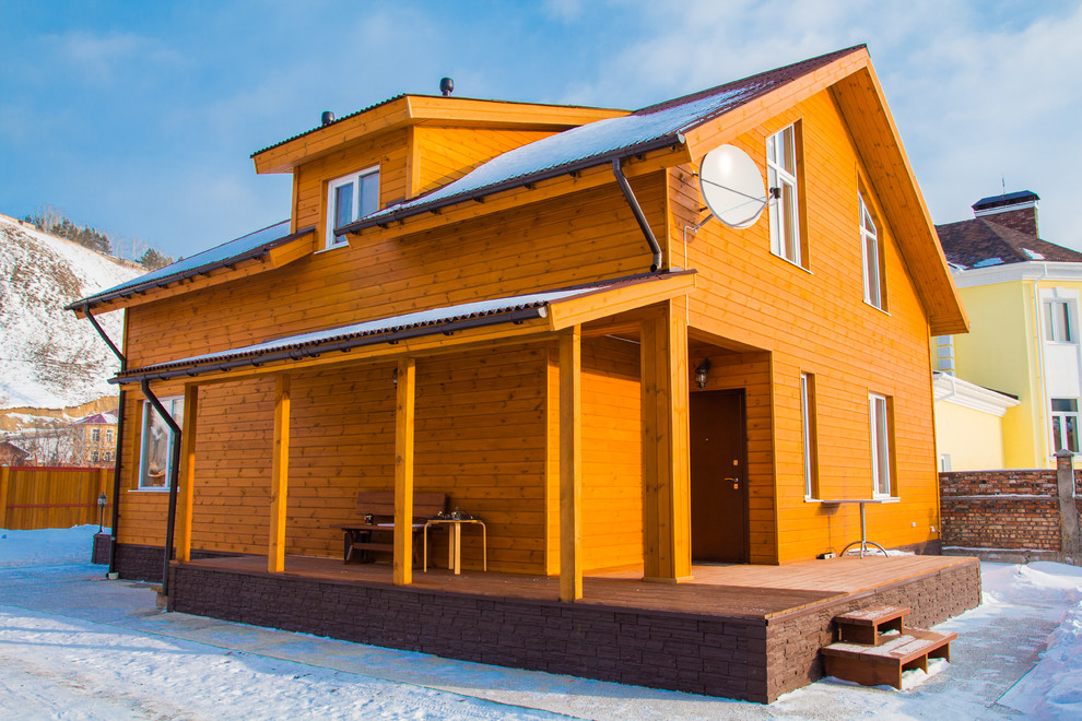 На фото: двухэтажный, деревянный дом с двускатной крышей с