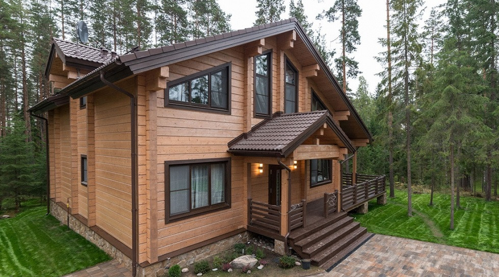 На фото: двухэтажный, деревянный, коричневый частный загородный дом среднего размера в скандинавском стиле с двускатной крышей и металлической крышей