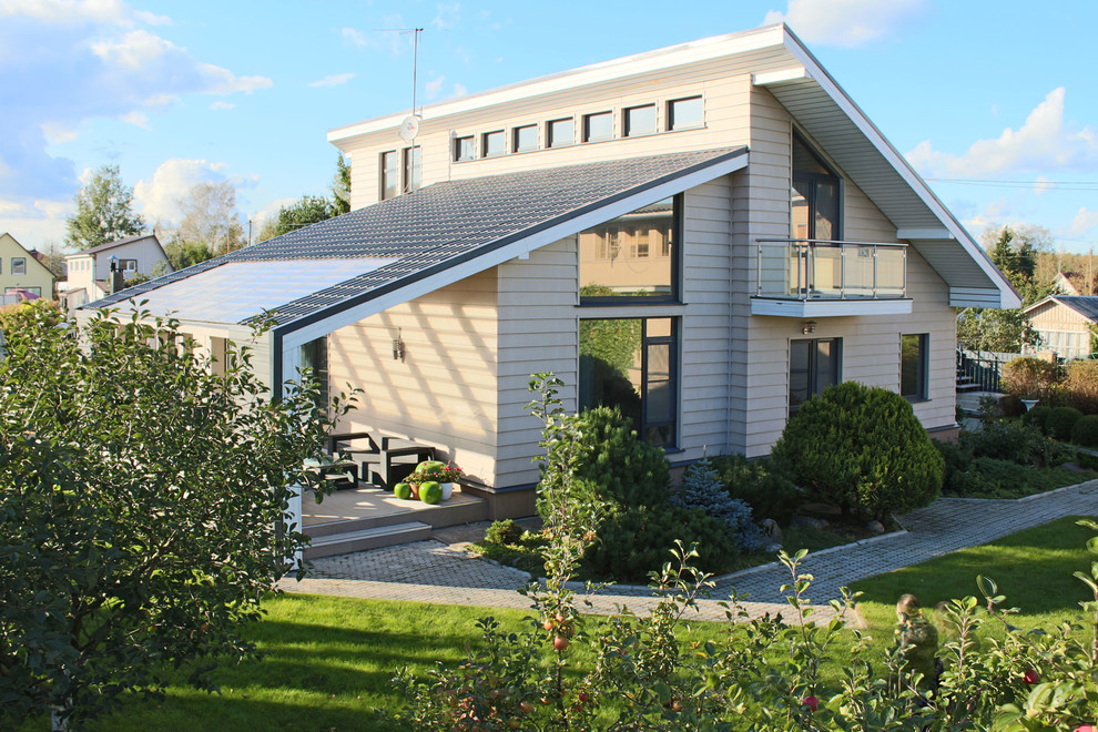 Immagine della villa beige contemporanea a un piano di medie dimensioni con rivestimento in vinile, tetto a capanna e copertura in metallo o lamiera