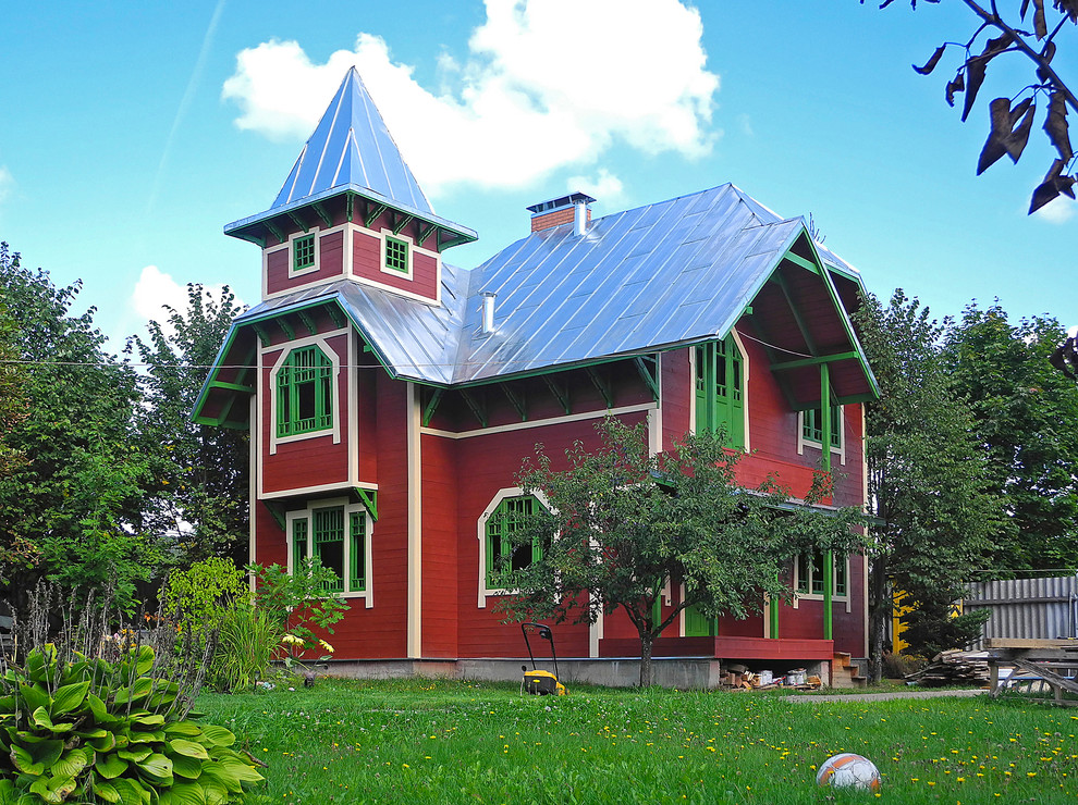 На фото: маленький, двухэтажный, деревянный, красный частный загородный дом в стиле кантри с двускатной крышей и металлической крышей для на участке и в саду