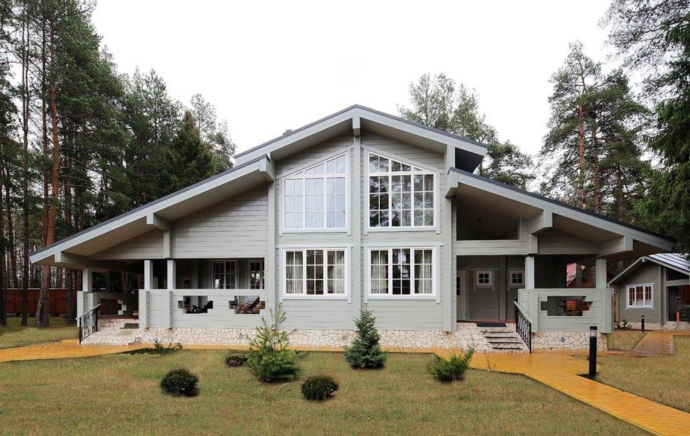 Immagine della villa grigia contemporanea a due piani con rivestimento in legno e tetto a capanna