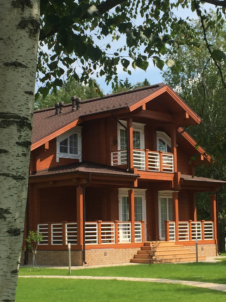 Стильный дизайн: двухэтажный, коричневый частный загородный дом в классическом стиле - последний тренд
