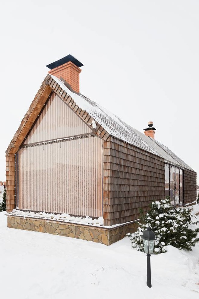 Ejemplo de fachada beige nórdica de tamaño medio de una planta con revestimiento de madera y tejado a dos aguas
