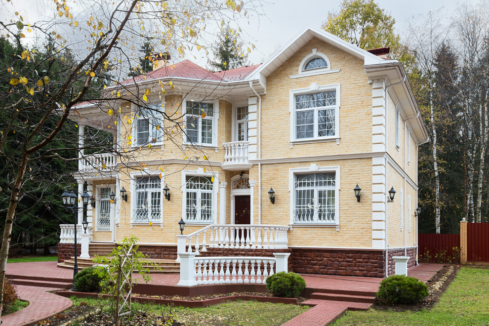 Immagine della facciata di una casa gialla classica a due piani