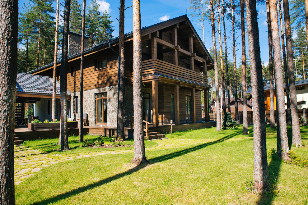 Diseño de fachada de casa marrón de estilo de casa de campo grande de dos plantas con revestimiento de madera y tejado a dos aguas