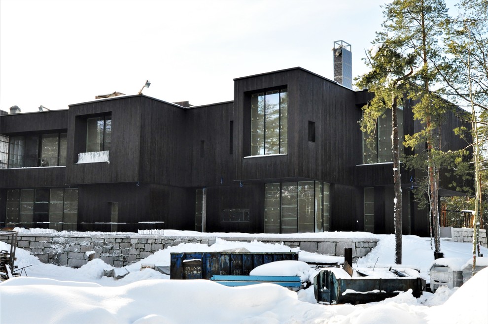 Foto della facciata di una casa nera contemporanea con rivestimento in legno