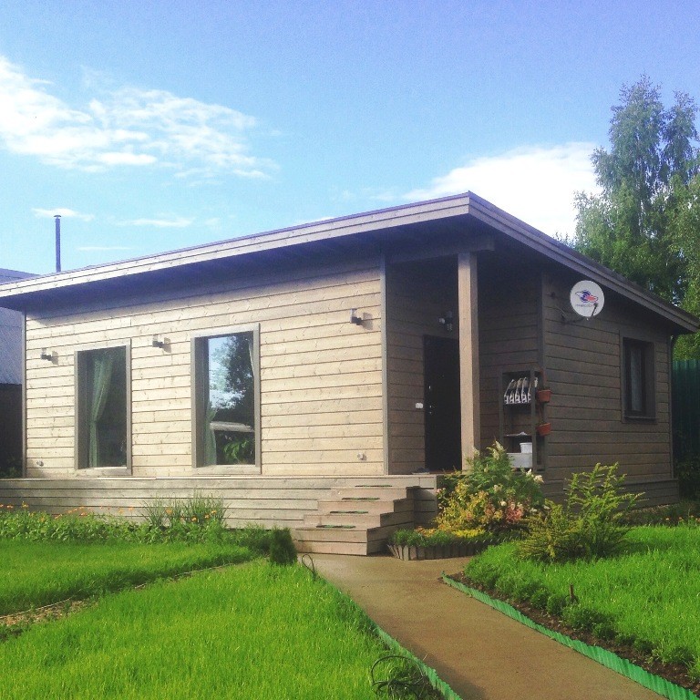 Cette photo montre une petite façade de maison grise scandinave en bois de plain-pied avec un toit en appentis et un toit en shingle.