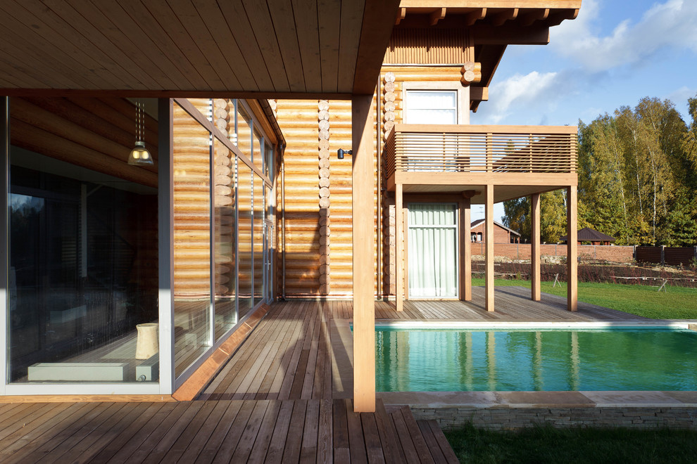Immagine della villa contemporanea a due piani con rivestimento in legno, tetto a capanna e copertura in tegole