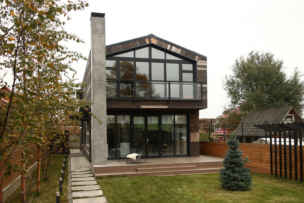 Идея дизайна: двухэтажный, коричневый, деревянный частный загородный дом среднего размера в современном стиле с двускатной крышей и металлической крышей