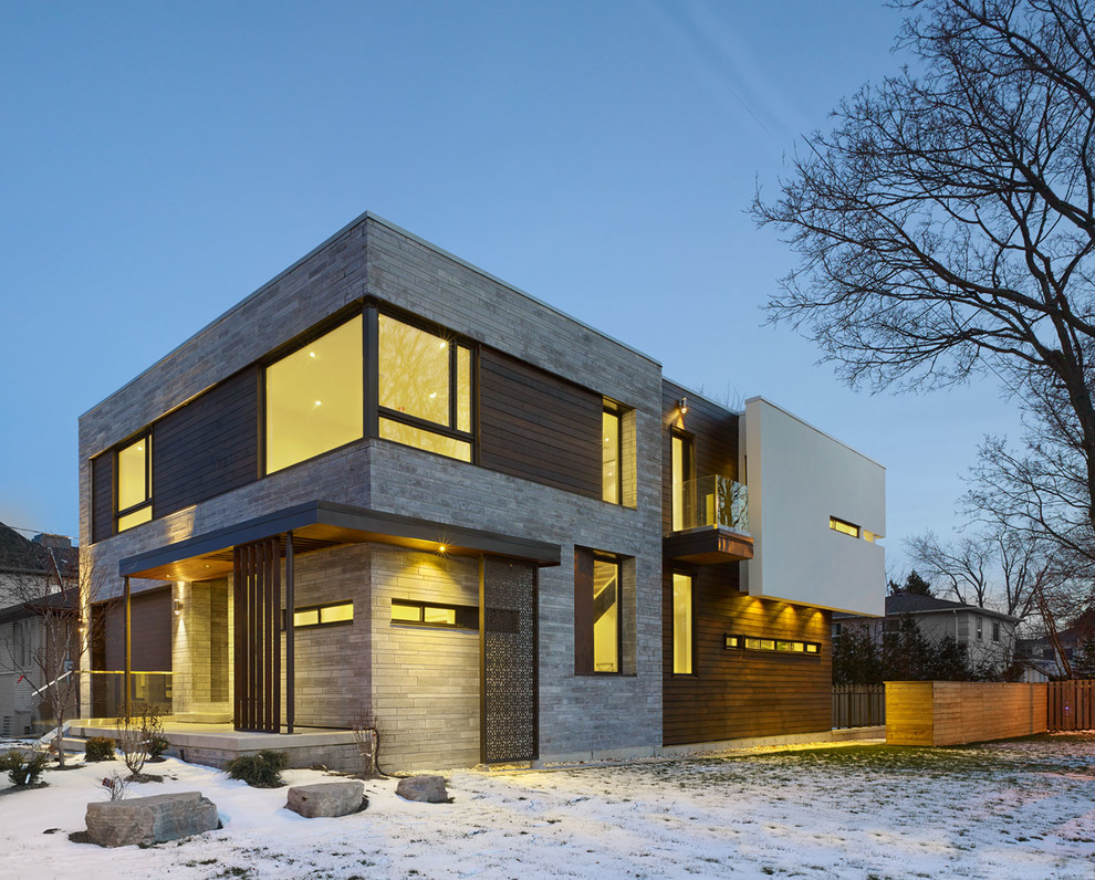 Cette photo montre une façade de maison grise tendance à un étage avec un toit plat et un revêtement mixte.