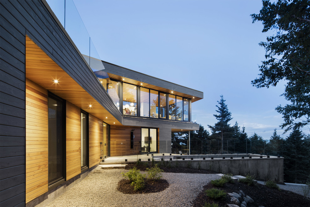 Diseño de fachada de casa multicolor actual de dos plantas con revestimiento de madera y tejado plano